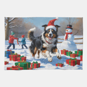 Raucollie läuft im Schnee mit Weihnachtsmütze Geschirrtuch