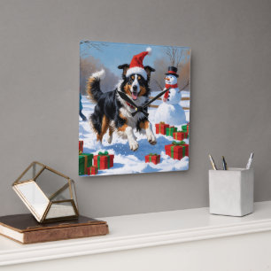 Raucollie läuft im Schnee mit Weihnachtsmütze Quadratische Wanduhr