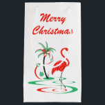 Red Christmas Flamingo Frohe Weihnachten klein Kleine Geschenktüte<br><div class="desc">Ein lustiges, festliches, flamingo-Design mit einer Retro-Touch in Rot und Grün. Ein roter Flamingo weht im Wasser neben einer Palme, die mit Weihnachtsbaumchen und Band dekoriert ist. Ein individuell anpassbares Design für Sie, um mit Ihrem eigenen Text, Bildern und Ideen zu personalisieren. Ein originelles digitales Kunstbild, das von Jess Perry...</div>