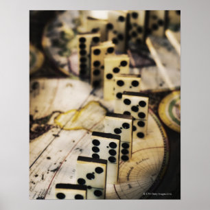 Reihe von Dominosteinen auf der alten Weltkarte Poster