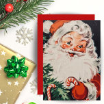Retro Santa mit Candy Canes Custom Christmas Feiertagskarte<br><div class="desc">Diese Weihnachtskarte aus der Mitte des Jahrhunderts beherbergt einen fröhlichen Weihnachtsmann,  der einen Zuckerrohr mit einem Blick auf einen Weihnachtsbaum in der Ecke hält,  der mit Bonbons geschmückt ist. Personalisieren Sie diese,  indem Sie die Nachricht auf der Rückseite anpassen und/oder Ihren Namen hinzufügen.</div>
