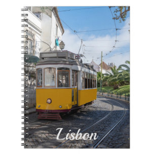 Retrogelbe Straßenbahn auf einer Straße in Lissabo Notizblock