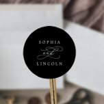 Romantische kalligraphische Black Wedding-Umschlag Runder Aufkleber<br><div class="desc">Diese romantischen kalligraphischen Umschlag Aufkleber sind perfekt für eine Hochzeit. Das moderne klassische Design besticht durch extravagante Wirbel und skurrile Schnörkel mit einer prächtigen,  eleganten Typografie. Personalisieren Sie das Etikett mit den Namen der Braut und des Bräutigams.</div>