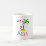 Rosa Flamingo in einer Weihnachtsmannmütze von Pal Tasse<br><div class="desc">Festliche Tasse mit einer niedlichen Abbildung eines rosa Flamingos in einer roten Weihnachtsmannmütze. Stehend neben einer grünen Palme auf einem Hang mit gelbem Sand. Ein extravagantes Wirbles Weihnachtsbaumdesign wird neben dem Text Frohe Weihnachten platziert. Geschrieben in der Farbe rosa in einem extravaganten handgeschriebenen Schriftart.</div>