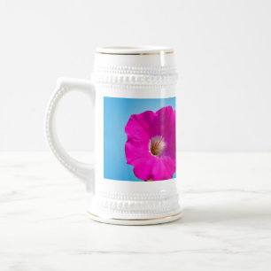 Rosa Petunia Blume im blauen Hintergrund. Bierglas