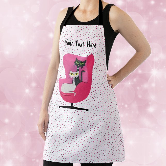 Rosa Stuhl Mitte des Jahrhunderts mit zwei Katzen  Schürze (Mid century elegant cats in a vintage chair on white kitchen apron with pink polka dots.)
