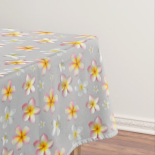 Rosa und weiße Plumeria-Blüten auf Hellgrau Tischdecke