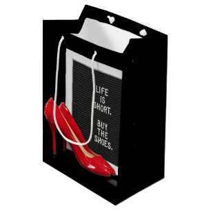 Rote High Heels mit Zeichen Mittlere Geschenktüte