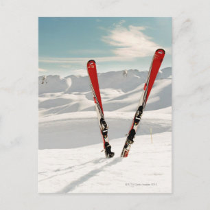 Rote Paare des Skis stehend im Schnee Postkarte