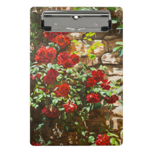Rote Rosen gegen eine Steinmauer Mini Klemmbrett