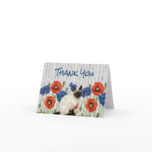 Rote und blaue Pflaumen mit siamesischer Katze