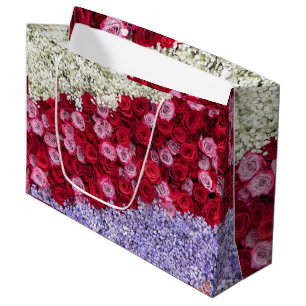 Rote und rosa Rosen mit farbenfroher Gypsophila Große Geschenktüte