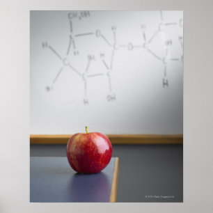 Roter Apfel, der auf Lehrerschreibtisch sitzt Poster