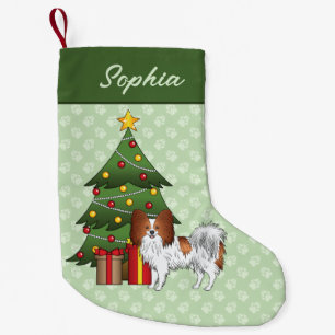 Roter und weißer Papillon-Hund an einem Weihnachts Kleiner Weihnachtsstrumpf