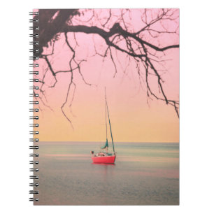 ROTES BOOT AM STRAND WÄHREND DER SONNE NOTIZBLOCK
