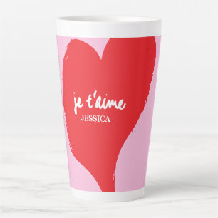 Rotes Herz mit je t’aime-Text auf rosa Hintergrund Milchtasse