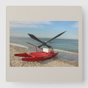 Rotes Rettungsboot am Strand - Erinnerungen an das Quadratische Wanduhr