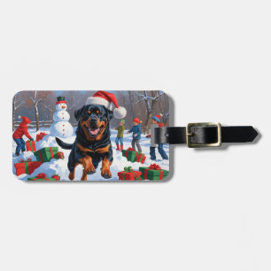 Rottweiler läuft im Schnee mit Weihnachtsmütze Gepäckanhänger