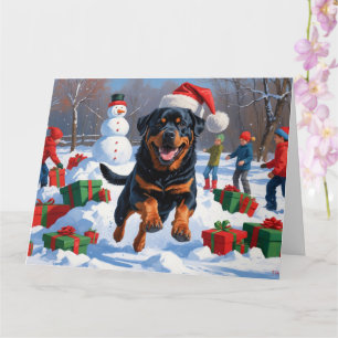 Rottweiler läuft im Schnee mit Weihnachtsmütze Karte