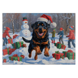 Rottweiler läuft im Schnee mit Weihnachtsmütze Schneidebrett