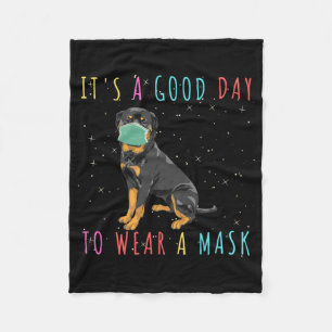 Rottweiler trage eine Maske, die einen guten Tag z Fleecedecke