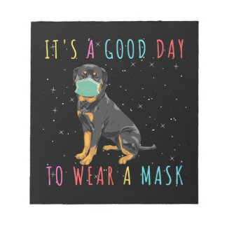 Rottweiler trage eine Maske, die einen guten Tag z Notizblock