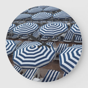 Rows Of Striped Beach Umbrellas With Sun Beds Große Wanduhr