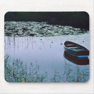 Ruderboot auf einem kleinen See, umgeben von Wasse Mousepad