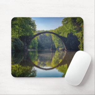 Rundgrau-Felsbrücke über einen Fluss im Wald Mousepad
