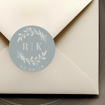 Rustikales Blue Botanical Wreath Wedding Monogram Runder Aufkleber<br><div class="desc">Maßgeschneiderte Botanische Hochzeitsticker mit elegantem,  beigen Kranz mit Paarinitialen und Hochzeitstermin auf staubblauem Hintergrund. Ideal für Hochzeiten speichern Sie die Daten,  Umschläge,  Gastgeschenk Hochzeit Packungen und mehr.</div>