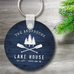 Rustikales Seehaus Oars Trees Blue Wood Print Roun Schlüsselanhänger<br><div class="desc">Ein wunderschöner, rustikaler Schlüsselanhänger mit Familienname und "Lake House" oder anderen Wunschtexten mit Datum und Lage. Dieses individuelle Design besticht durch eine weiße Silhouette von gekreuzten Bootskörben und Kiefernbäumen auf Holzplanken in blauen Farbtönen. Ideal für Zuhause und Ferienhäuser mit Firmennamen, wo ein rustikales Naturthema gebraucht wird. Um mehr Designs wie...</div>