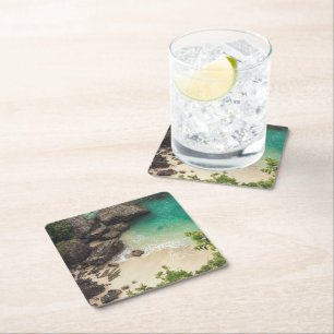 Sandstrand mit grünen Bäumen, Felsen und Ozean Rechteckiger Pappuntersetzer