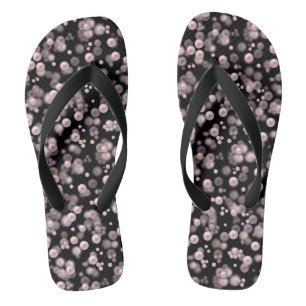 Scatterings von rosa und weißen Perlen auf schwarz Flip Flops