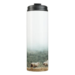 SCHAFENHERD AUF BROWN GRASS FIELD WÄHREND DES TAGE THERMOSBECHER