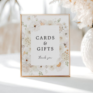 Schild mit weißen Blumenkarten und Geschenken