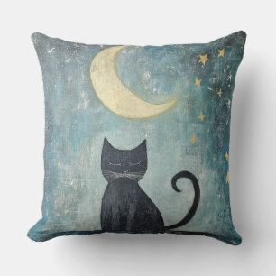 Schlafende schwarze Katze mit zunehmendem Mond und Kissen