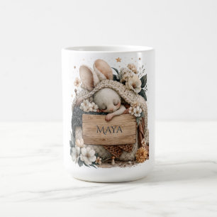 Schlafendes Babykaninchen mit gestrickter Decke un Kaffeetasse