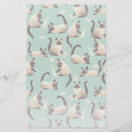 Schlechte siamesische Katzen klopfen über Briefpapier