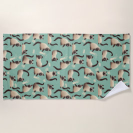 Schlechte siamesische Katzen klopfen über Strandtuch