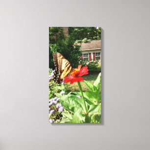 Schmetterling auf Blume vor dem Haus - Vertikal Leinwanddruck