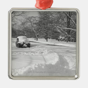 Schnee mit einer Kappe bedecktes Auto auf Straße Silbernes Ornament