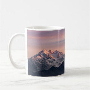 SCHNEE ÜBERDECKTE BERGE WÄHREND DES TAGES0 KAFFEETASSE