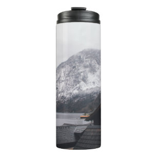 SCHNEEBEDECKTER BERG IN DER NÄHE DES WASSERKÖRPERS THERMOSBECHER