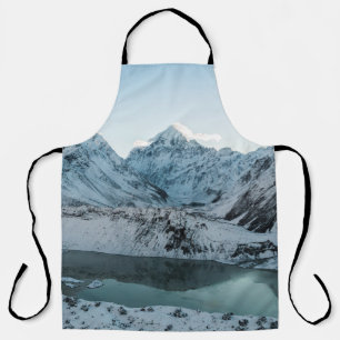 SCHNEEBEDECKTER BERG NAHE EINEM GEWÄSSER SCHÜRZE