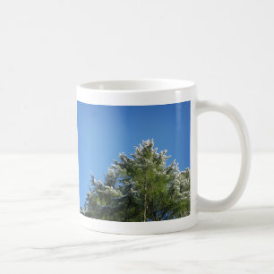 Schneebedeckter Kiefernbaum auf blauem Himmel Tasse