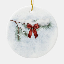 schneebedeckter Kiefernzweig mit festlichem rotem  Keramik Ornament