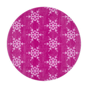 Schneeflocken, blassrosa Kristalle auf Magenta Schneidebrett