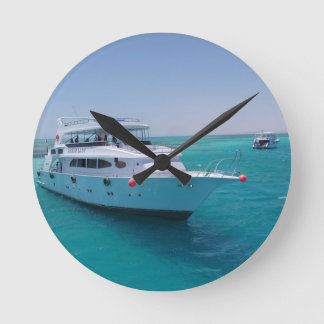Schneeweiße Yacht in der Nähe der weißen Insel im Runde Wanduhr