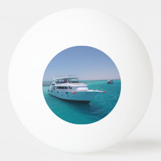 Schneeweiße Yacht in der Nähe der weißen Insel im Tischtennisball