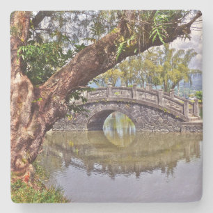 SCHÖNE, ARCHIERTE STEINBRÜCKE, DIE IN POND SPIEGEL STEINUNTERSETZER